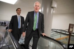 FILE - Senate Majority Whip John Cornyn, R-Texas, arrives to join Senate Majority leader Mitch McConnell in unveiling the Republicans' health care bill, June 22, 2017.