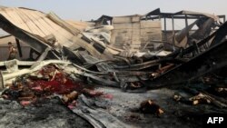 FILE - Yemeni men inspect the damage at a factory allegedly targeted by Saudi-led coalition's airstrikes in the Red Sea town of Hodeida, July 27, 2018.