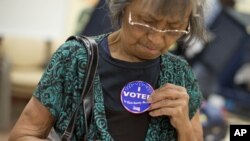 La hispana Aida Castillo muestra el distintivo de haber votado durante el sufragio temprano en Las Vegas, Nevada.