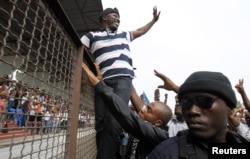Leader of the Young Patriots militia Charles Ble Goude (C) greets members of the militia and supporters of Ivory Coast's incumbent leader Laurent Gbagbo, during a rally in support of the Ivorian armed forces, at Champroux Stadium in Abidjan January 23, 2011.
