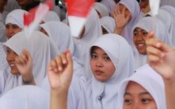 Ilustrasi. Siswa sekolah menyambut pebisnis miliarder Indonesia yang berkunjung yang juga saat itu menjadi Ketua Golkar Aburizal Bakrie di sekolah mereka saat roadshow di Tangerang, pinggiran Jakarta, 10 Mei 2012. (Foto: Reuters/Matthew Bigg)