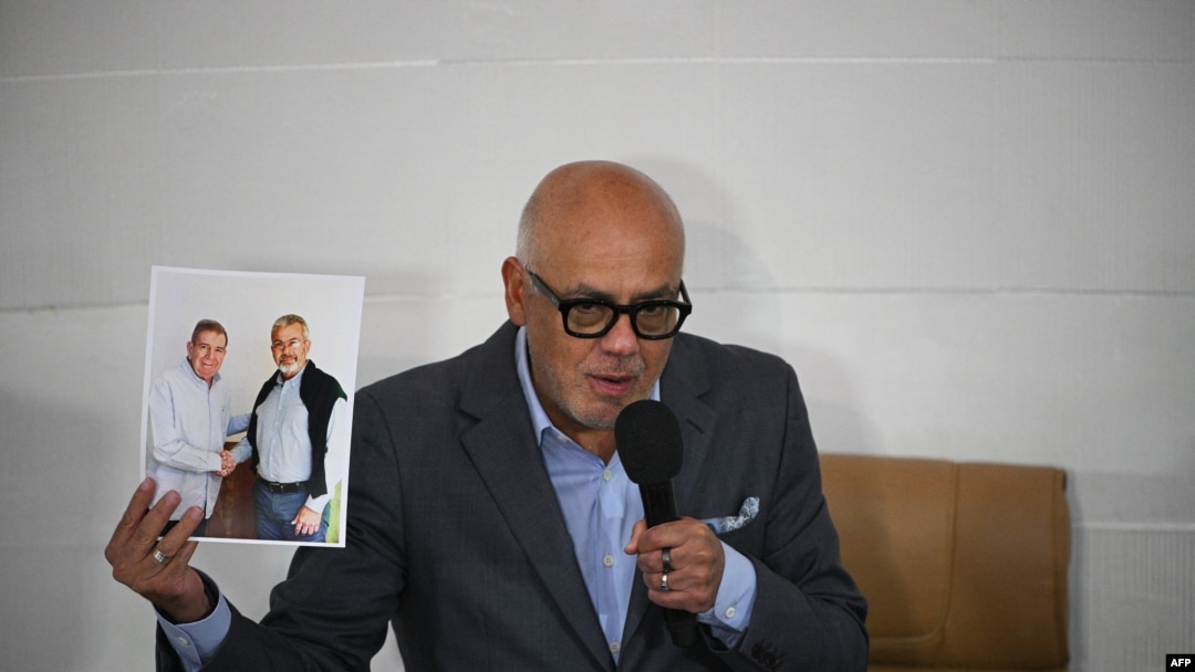 El presidente de la Asamblea Nacional, Jorge Rodríguez, muestra una imagen del excandidato presidencial opositor Edmundo González estrechando la mano del exrector del Consejo Nacional Electoral, Juan Carlos Delpino, ante la Asamblea Nacional en Caracas, el 17 de octubre de 2024.