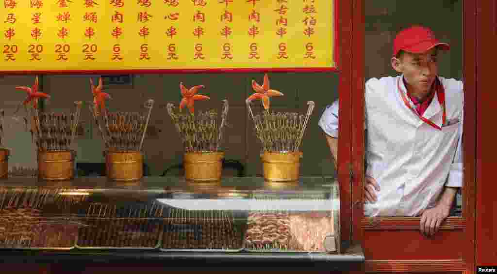 A food vendor waits for customers at a shopping district in Beijing. Growth in China&#39;s services sector slowed sharply in April to its lowest point since August 2011, a private sector survey showed on Monday.