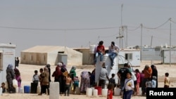 Syrian refugees collect water at the Al-Zaatari refugee camp in Mafraq, Jordan, near the border with Syria, Aug. 18, 2016.