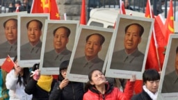 中国山西省太原一所大学的学生手举中共前领导人毛泽东的画像庆祝毛泽东诞辰120周年。（2013年12月21日）