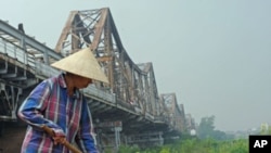 A farmer works in a field below the historical Long Bien bridge, in Hanoi, Vietnam, October 2009. (file photo)