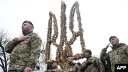 Ukrainian paratroopers of the 80th Separate Galician Air Assault Brigade take a part in the presentation of a 7.5-metre Trident, a Ukrainian national symbol, in Lviv on Dec. 23, 2024, amid the Russian invasion of Ukraine.