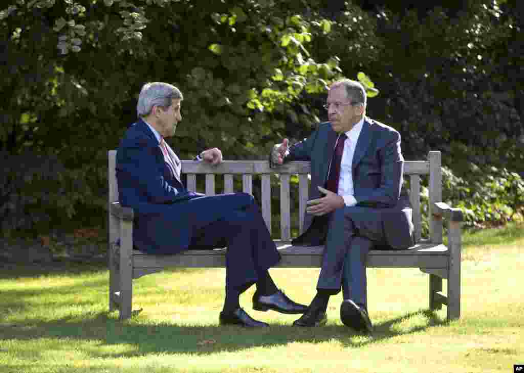 U.S. Secretary of State John Kerry&nbsp; and Russian Foreign Minister Sergey Lavrov sit together on the grounds of the Chief of Mission Residence in Paris, France, Oct. 14, 2014. 