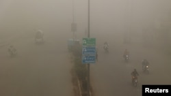 People commute on a smoggy morning in Peshawar, Pakistan.