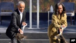 Former President Barack Obama, left, and former first lady Michelle Obama toss shovels of dirt during a groundbreaking ceremony for the Obama Presidential Center in Chicago, Sept. 28, 2021.