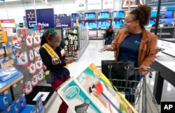 Fast Checkout-Holiday: Walmart associate Shanay Bishop, left, checks out customer Carolyn Sarpy on the sales floor as part of the "Check Out With Me" program at a Walmart Supercenter in Houston, Nov. 9, 2018.