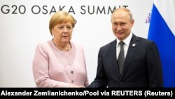 Ruski predsednik Putin i nemačka kancelarka Merkel rukuju se za vreme sastanka na marginama samita G-20 u Osaki. 