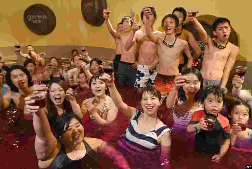 Bathers raise their glasses, containing 2014 vintage Beaujolais Nouveau wine, at a &quot;wine spa&quot; in Hakone town, Kanagawa prefecture, some 100 kilometers west of Tokyo, after an embargo on the wine was removed.