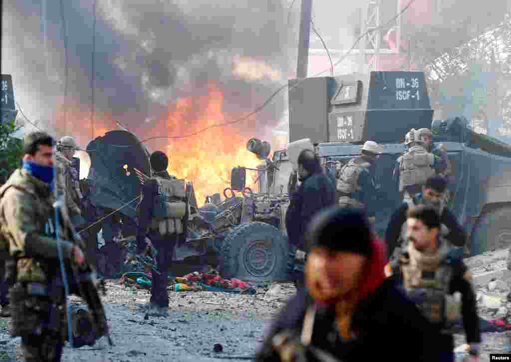 Iraqi Special Operations Forces (ISOF) react after a car bomb exploded during an operation to clear the al-Andalus district of Islamic State militants, in Mosul.