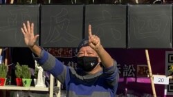 香港支聯會主席李卓人不滿食環署終止維園年宵攤檔合約，高舉反送中運動”五大訴求、缺一不可”的抗議手勢。(美國之音 湯惠芸拍攝)