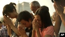 Visitors pray for WWII victims at the Hiroshima Peace Memorial Park in Hiroshima, Japan, Aug. 6, 2015. 