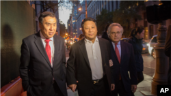 2015年10月25日，吳立勝獲保釋離開聯邦法院，左為律師莫虎，右為律師本傑明‧布 拉夫曼