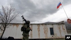 A Russian soldier marches as he and comrades block the Ukrainian infantry base in Perevalne, Ukraine, March 4, 2014. 