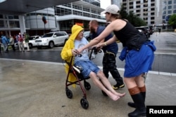 Aid workers push evacuee Frank Andrews into the George R. Brown Convention Center after Hurricane Harvey inundated the Texas Gulf coast with rain causing widespread flooding, in Houston, Aug. 27, 2017.