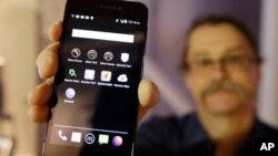 FILE - In this July 30, 2014, file photo, Silicon Valley pioneer and Silent Circle co-founder Jon Callas holds up Blackphone with encryption apps displayed on it at the Computer History Museum in Mountain View, California.