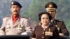 FILE - Indonesian President Megawati Sukarnoputri, flanked by her adjutant Colonel Budi Gunawan (R) and ceremony commander Police Commissioner Sunaryono (L) at the 56th anniversary of the country's police force in Jakarta, July 1, 2002.