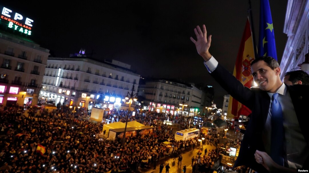 El líder de oposición de Venezuela, Juan Guaidó, saluda desde el balcón de la sede del gobierno regional de España a miles de sus compatriotas que acudieron a recibirlo, en Madrid. Enero 25, de 2020.