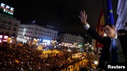 El líder de oposición de Venezuela, Juan Guaidó, saluda desde el balcón de la sede del gobierno regional de España a miles de sus compatriotas que acudieron a recibirlo, en Madrid. Enero 25, de 2020.