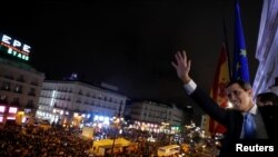 Venezuelan opposition leader Juan Guaido gestures toward supporters from the balcony of the headquarters of Madrid's regional government in Madrid, Spain, Jan. 25, 2020.