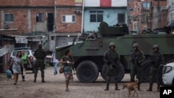 Brazilian marines stand in guard next to an armored vehicle a during surprise operation in Kelson's slum in Rio de Janeiro, Feb. 20, 2018.