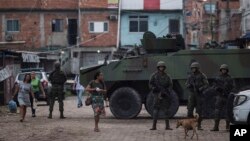 Brazilian marines stand in guard next to an armored vehicle a during surprise operation in Kelson's slum in Rio de Janeiro, Feb. 20, 2018.