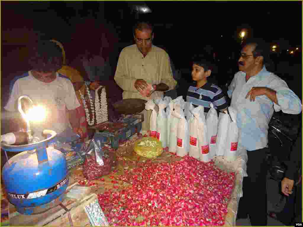 کراچی کے ایک قبرستان کے باہر شہری پھولوں کی پتیاں خرید رہے ہیں۔