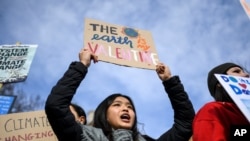 FILE - Children gather at Parliament Square holding placards and flags, as they protest against climate change, in London, Feb. 14, 2020.