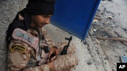 FILE - A Libyan soldier reloads his weapon during clashes with Islamist militias in Benghazi, Libya.