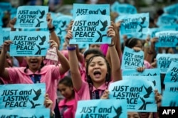 High school students hold banners calling for just and lasting peace as Philippine President Rodrigo Duterte marks his first 100 days in office in Manila, Oct. 7, 2016.