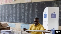 An official from the Independent National Electoral Commission (CENI) counts votes in a polling station at the Imara College in Lubumbashi on December 21, 2023.