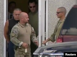 Cesar Altieri Sayoc (in dark shirt), who was arrested during an investigation into a series of parcel bombs, is escorted from an FBI facility in Miramar, Fla., Oct. 26, 2018, in this still image from video.