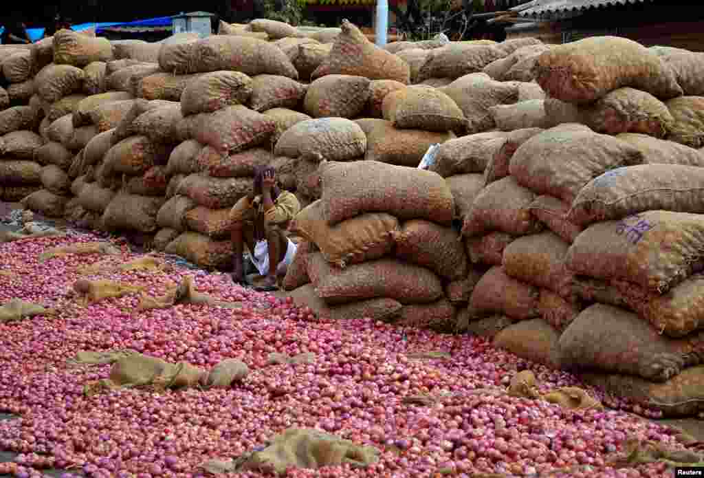 Seorang pedagang bawang merah menunggu pembeli di Bengaluru, India.