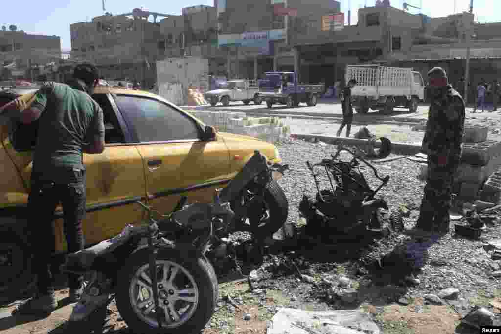 A police officer examines a vehicle that was used in a car bombing in Baghdad's Sadr City, Sept. 30, 2013.