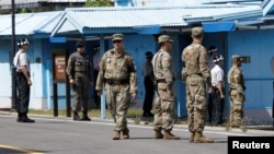 South Korean and U.S. Army soldiers stand guard at the border village of Panmunjom in the Demilitarized Zone, South Korea, Sept. 7, 2018. 