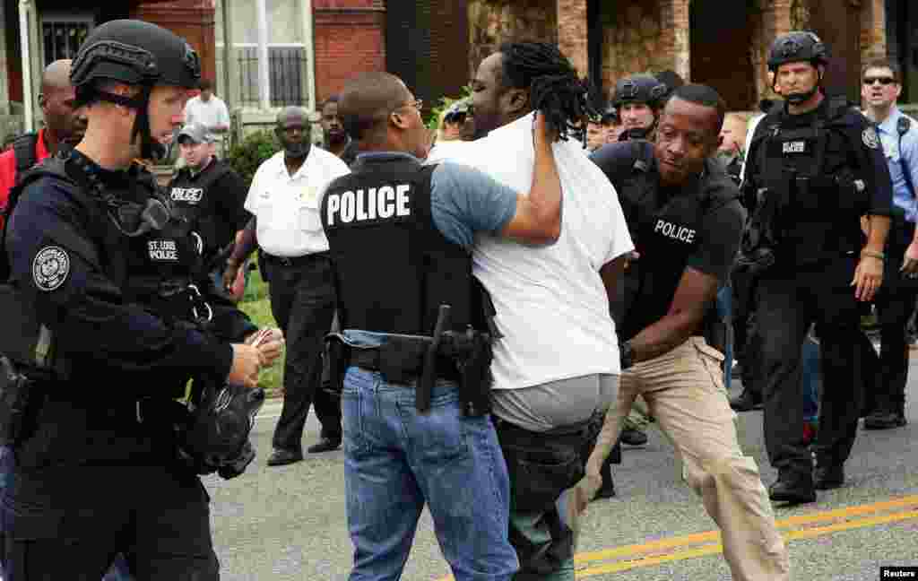 Police arrest a protester who was in the middle of the street after a shooting incident in St. Louis, Aug. 19, 2015.