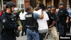Cảnh sát bắt giữ một người biểu tình đã ở giữa phố sau khi vụ nổ súng xảy ra ở thành phố St. Louis, bang Missouri ngày 19/8/2015.