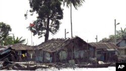 Shacks and houses line the shores of a river in Nigeria's Delta region