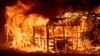 A structure burns as the Carr Fire races along Highway 299 near Redding, Calif., on July 26, 2018.