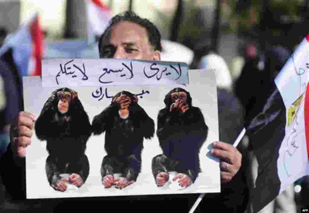 An Egyptian protester holds a poster Thursday, Feb. 10, 2011 during a march in Alexandria, Egypt. Labor unrest across the country gave powerful momentum to Egypt's wave of anti-government protests. With its efforts to manage the crisis failing, the gove