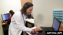 In this April 9, 2019 photo, Dr. Megan Mahoney types into a computer at the Stanford Family Medicine office in Stanford, California. “We want to do as much outside the walls of the clinic as we can,” says Mahoney, noting that this push to keep patients he