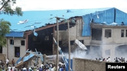 Onlookers gather near the bomb-damaged Shalom Church in the northern Nigerian city of Kaduna, June 17, 2012. 