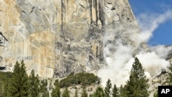 A cloud of dust rises at the base of El Capitan after a rock fall in Yosemite National Park, Calif., Sept. 27, 2107. An official said a British climber was killed an another injured in Wednesday's rock fall.