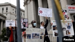 FILE - People and teachers protest against New York City mandated vaccines against the COVID-19 in front of the U.S. Courthouse in Manhattan, New York, Oct. 12, 2021.