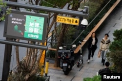 People walk through a CCTV (closed-circuit television system) monitored Gangnam district, equipped with artificial intelligence technology to monitor crowd density and detect early signs of crowd control disasters, in Seoul, South Korea, October 23, 2023.