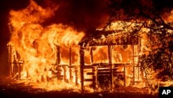 A structure burns as the Carr Fire races along Highway 299 near Redding, Calif., on July 26, 2018.